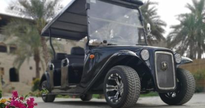 a black jeep parked in a driveway with palm trees