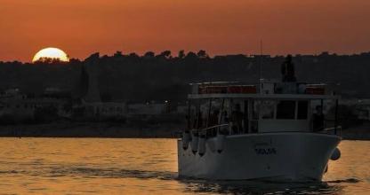 een boot in het water met de zonsondergang op de achtergrond