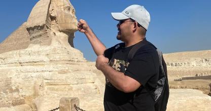 a man standing in front of the pyramid