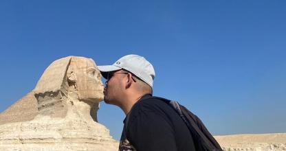 a man kissing the head of the sphinx