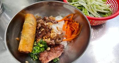 a bowl of food with meat and vegetables and a salad