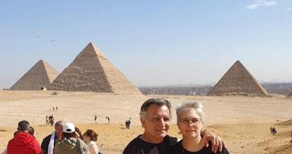 Un hombre y una mujer de pie frente a las pirámides.