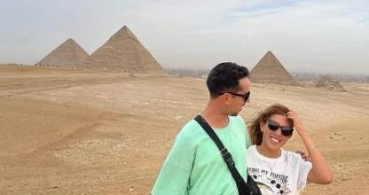 Un hombre y una mujer de pie frente a las pirámides.