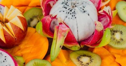Un montón de fruta con kiwis y naranjas.