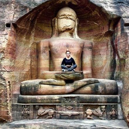 a man sitting on a large statue in a building