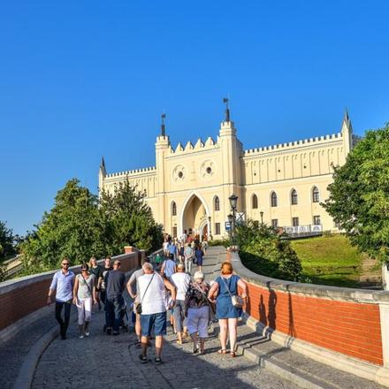 a group of people walking on a bridge in front of a building