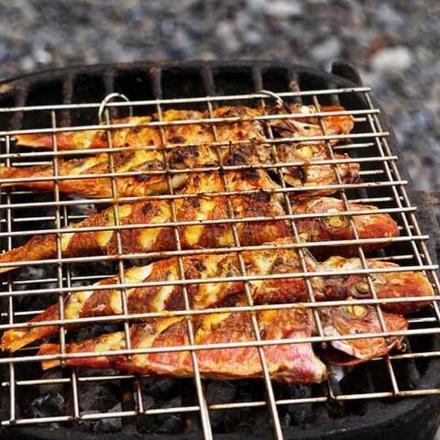 a bunch of chickens cooking on a grill