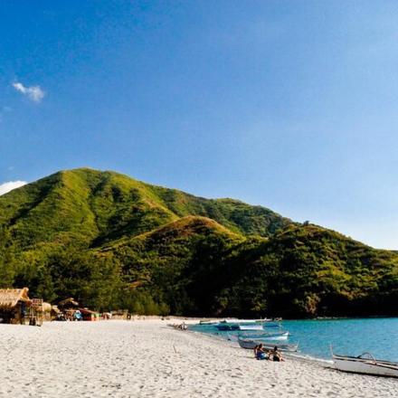 egy strand két csónakkal a homokban és egy hegy