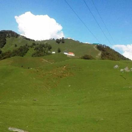 ein grüner Hügel mit einem Haus darauf