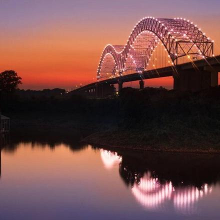 a roller coaster on a bridge at sunset