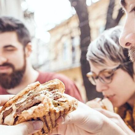 een man die een sandwich vasthoudt voor een vrouw