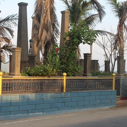 a retaining wall with palm trees and a fence