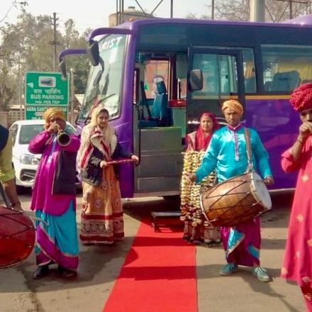 a group of people playing drums in front of a bus