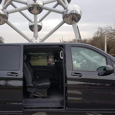 ein schwarzer Lieferwagen mit offener Tür auf einem Parkplatz