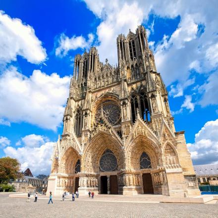 a large cathedral with people walking in front of it