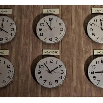 a group of clocks on a wall with different time zones