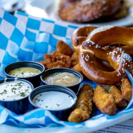 a plate of food with pretzels and dipping sauce