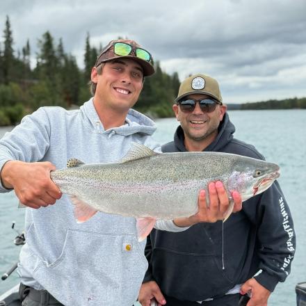 two men holding a large fish on a boat