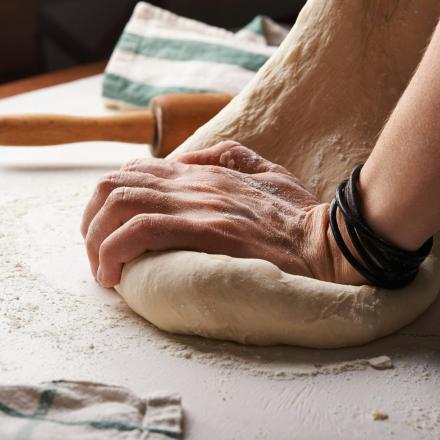 a person kneading a piece of dough on a table