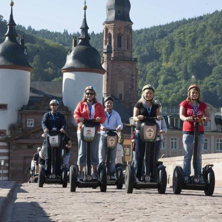 a group of people riding on segways on a bridge