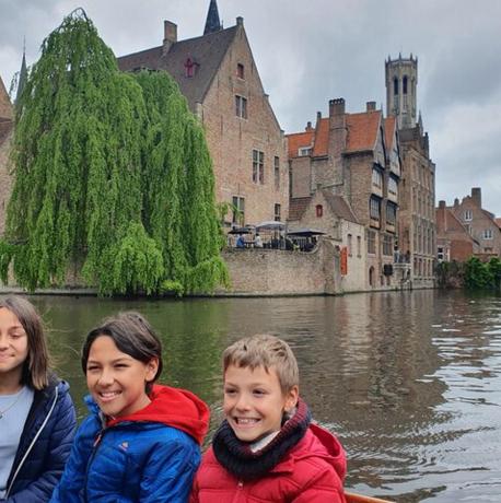 three children riding in a boat on a river