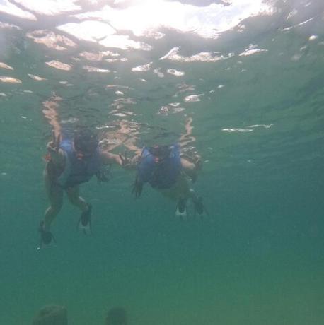 dos personas nadando en el agua del océano