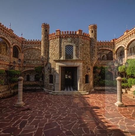 a large building with a brick courtyard with a doorway