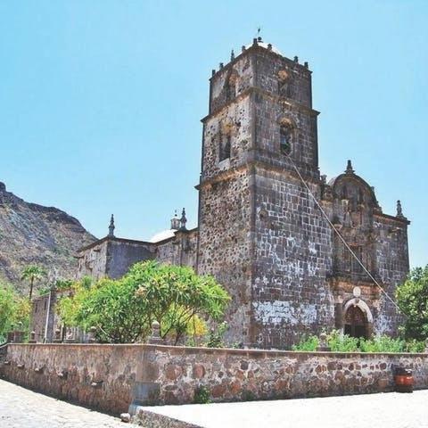 an old building with a clock tower on a hill