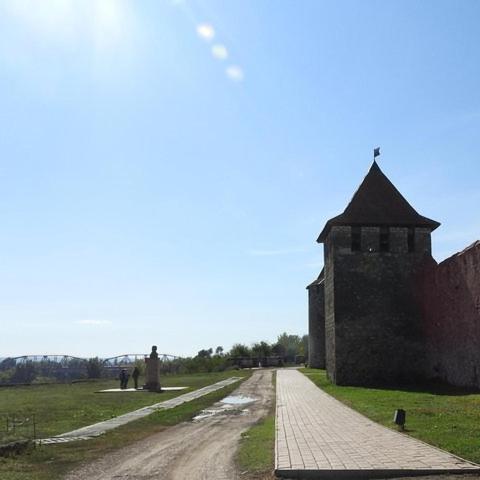 a dirt road next to a stone wall