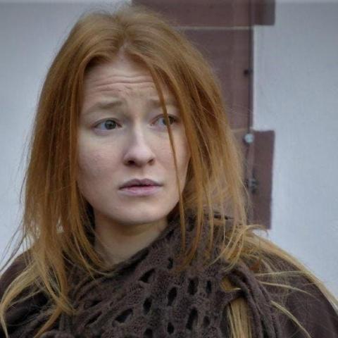 seorang wanita berambut merah melihat ke kamera