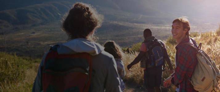 En gruppe venner er ude at vandre i bjergene på en solrig dag
