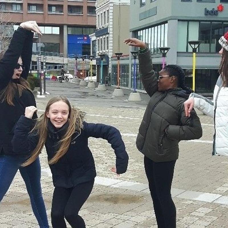 Un grupo de mujeres bailando en una calle de la ciudad.