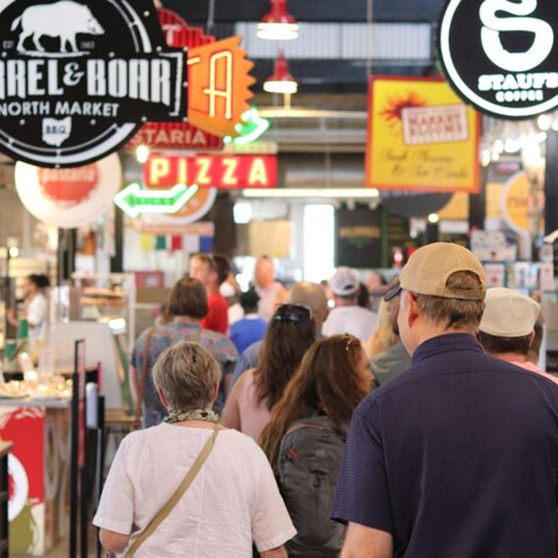 a group of people walking through a food store
