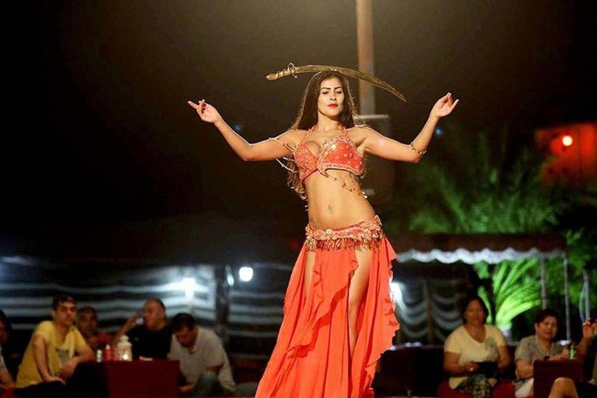 una donna con un vestito arancione che si esibisce su un palco