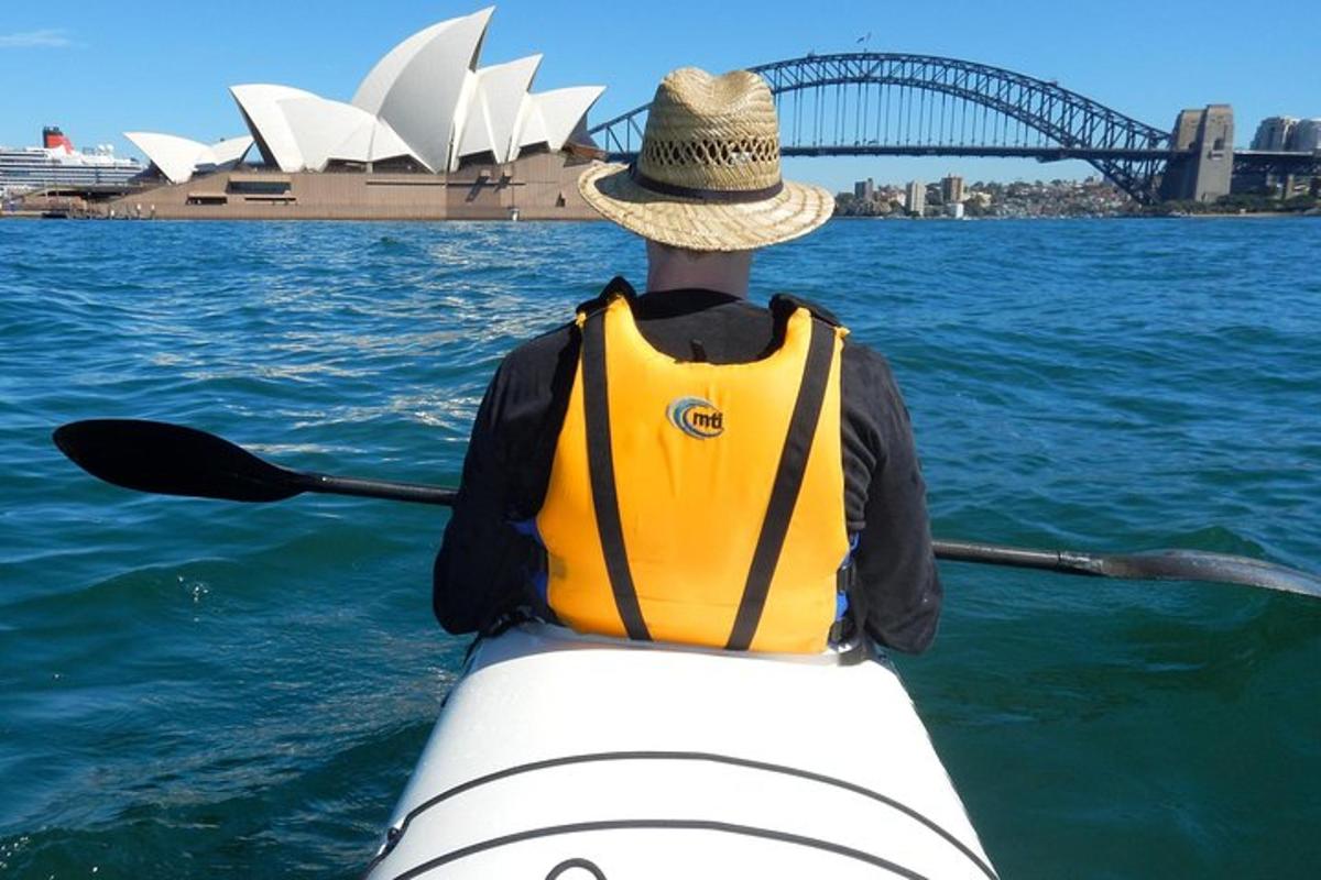 egy férfi kajakban a vízben a sydney-i operaházzal