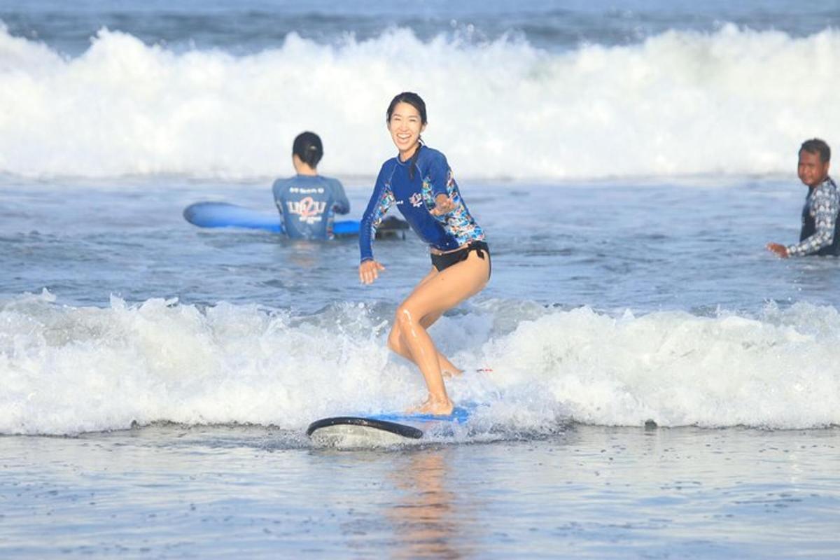 a young girl riding a wave on a surfboard in the ocean