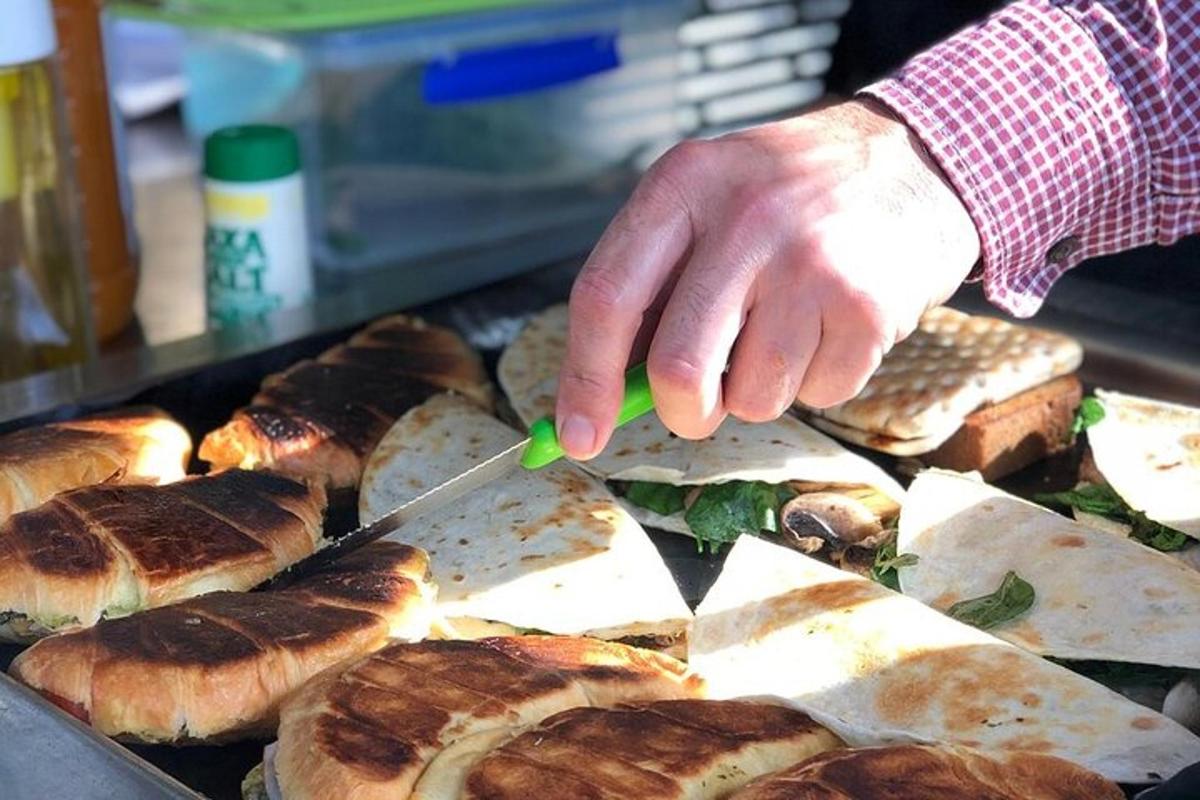 osoba krájející chléb nožem na grilu