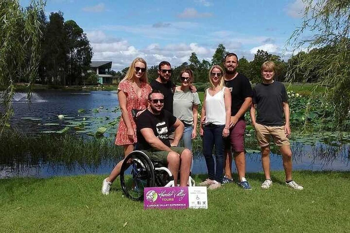 a group of people posing for a picture by a lake