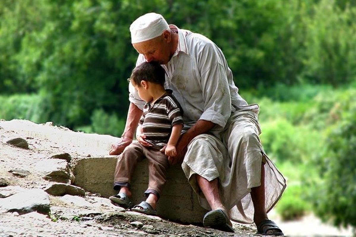 a man and a little boy sitting on a rock