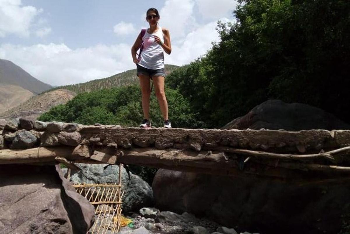 a woman standing on a bridge over a river