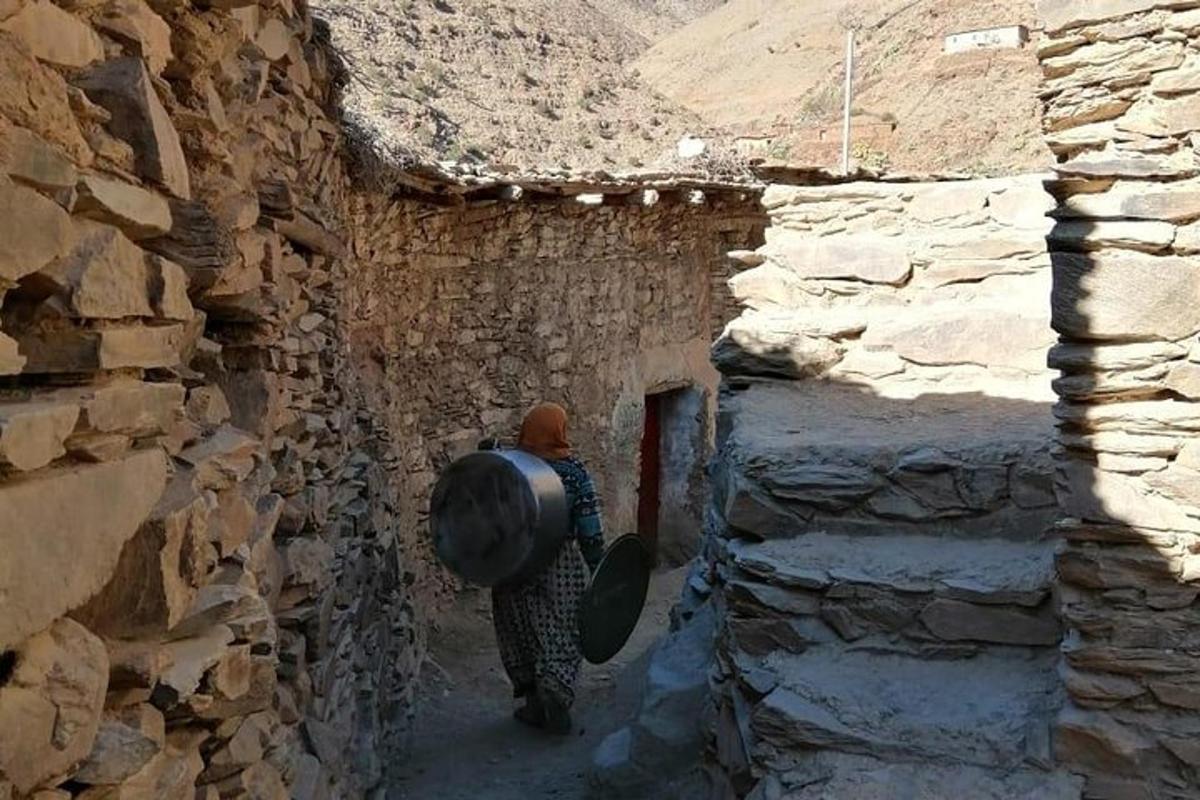 a man walking down an alley with a bucket on his back