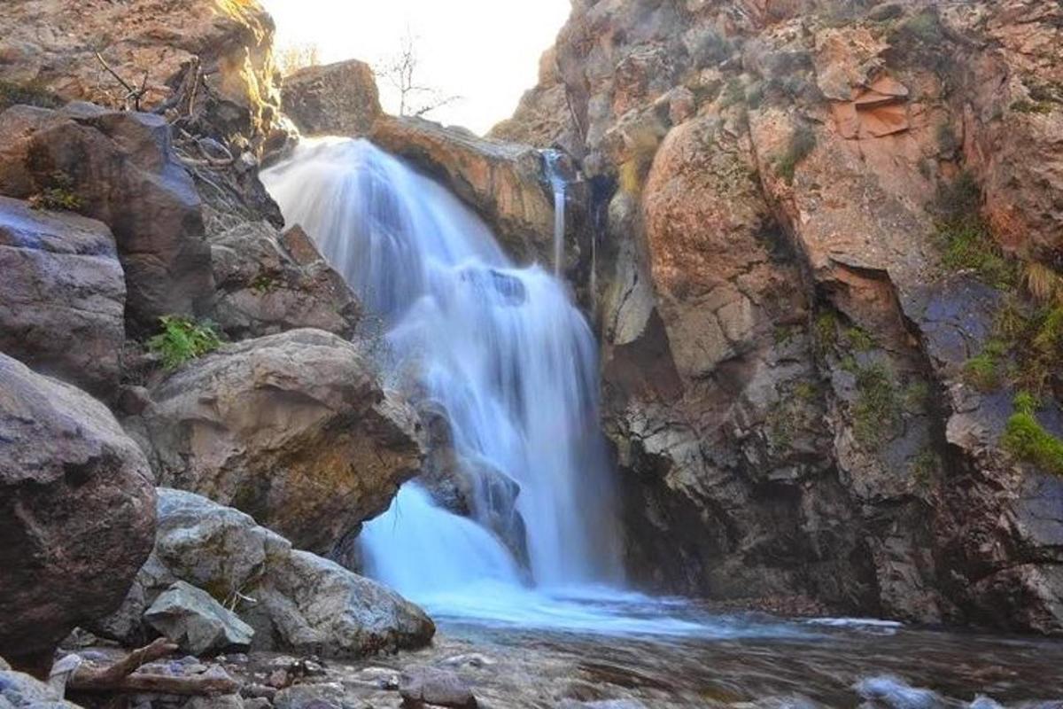 a waterfall on the side of a rocky mountain