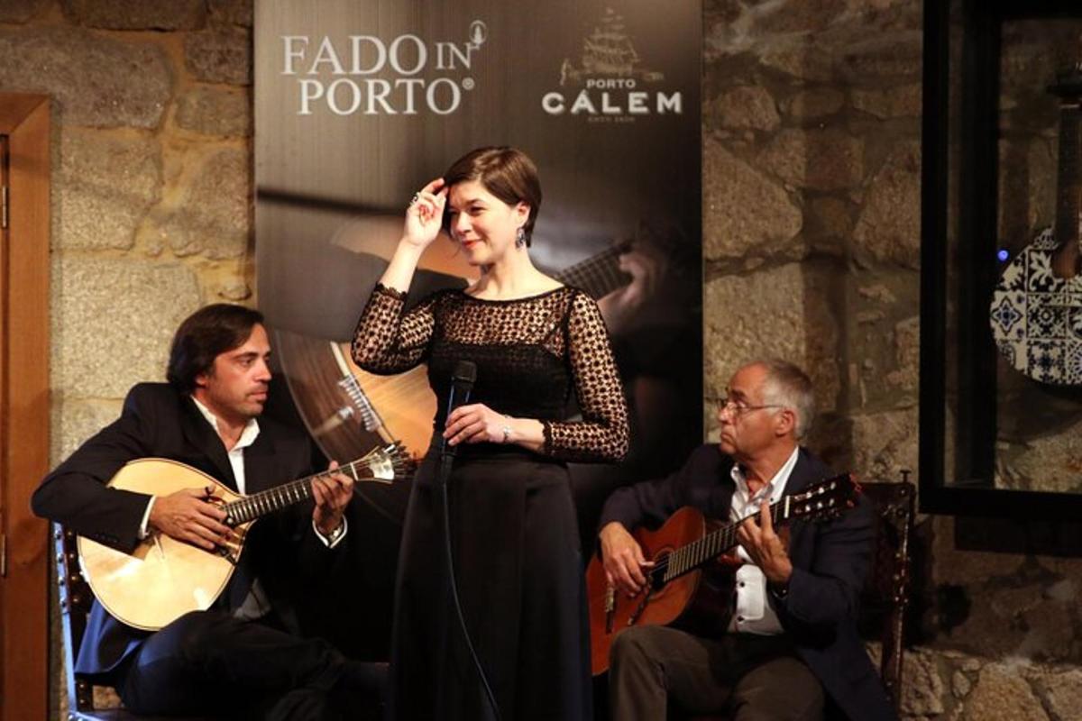 uma mulher em pé ao lado de um grupo de pessoas tocando instrumentos