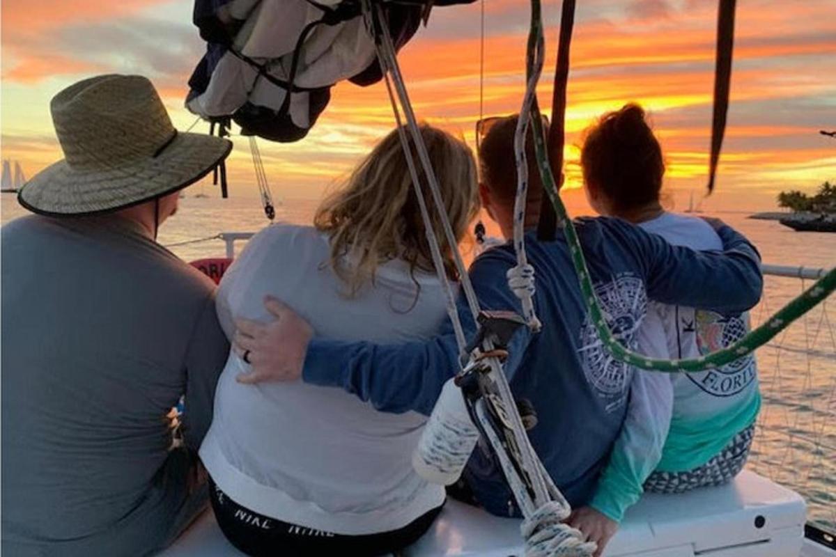 a group of women sitting on a boat watching the sunset