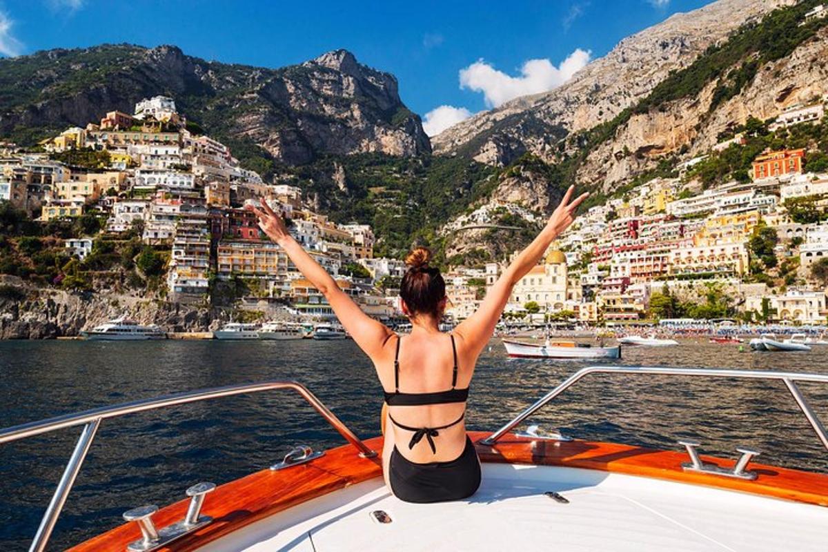 eine Frau im Bikini sitzt auf dem Bug eines Bootes