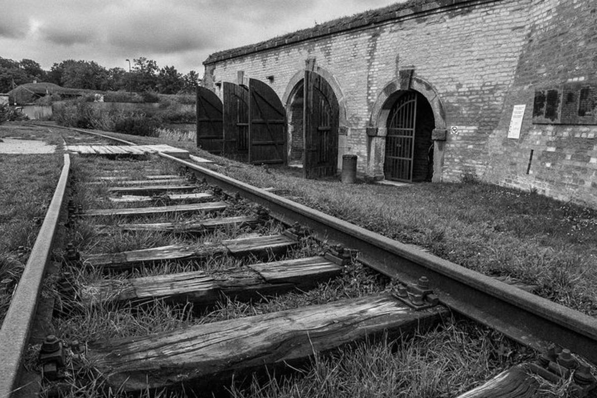 eine alte Bahnstrecke neben einem Backsteingebäude