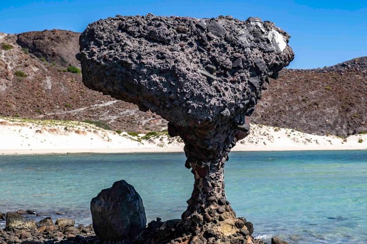 una roca situada a la part superior d'una platja vora l'aigua