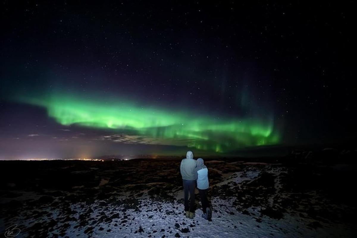 due persone che guardano l'aurora boreale nel cielo