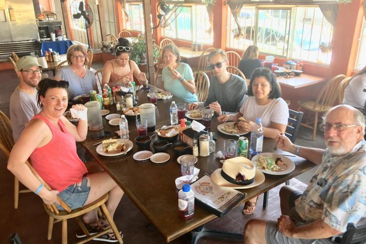 un gruppo di persone sedute a un tavolo che mangiano cibo