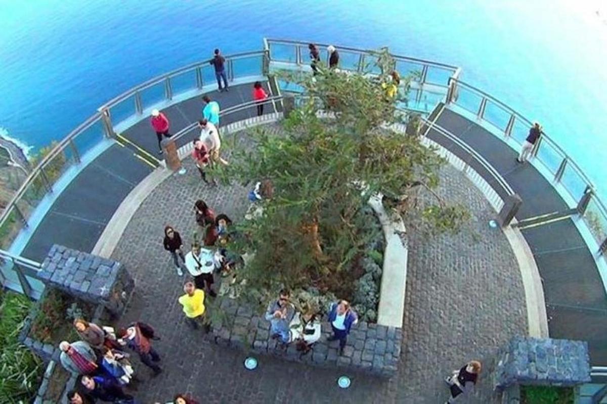 a group of people standing on a walkway near the water